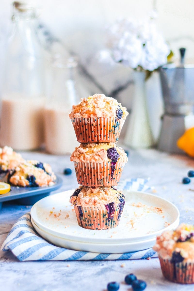 a stack of vegan blueberry lemon muffins on a white plate