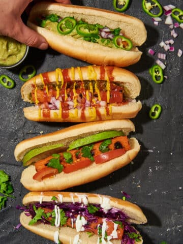 hand reaching in to grab one of 4 different carrot dogs