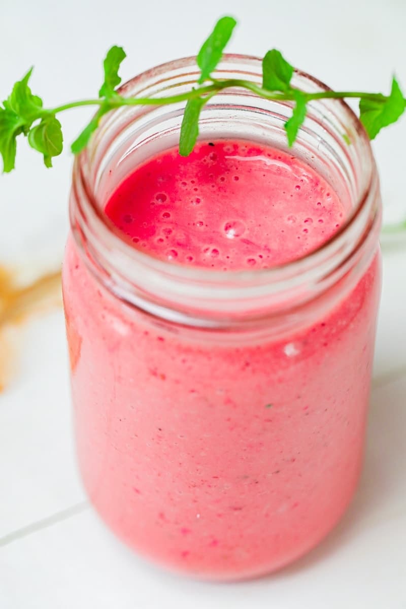 overhead closeup view of pink blender salad dressing on a white table