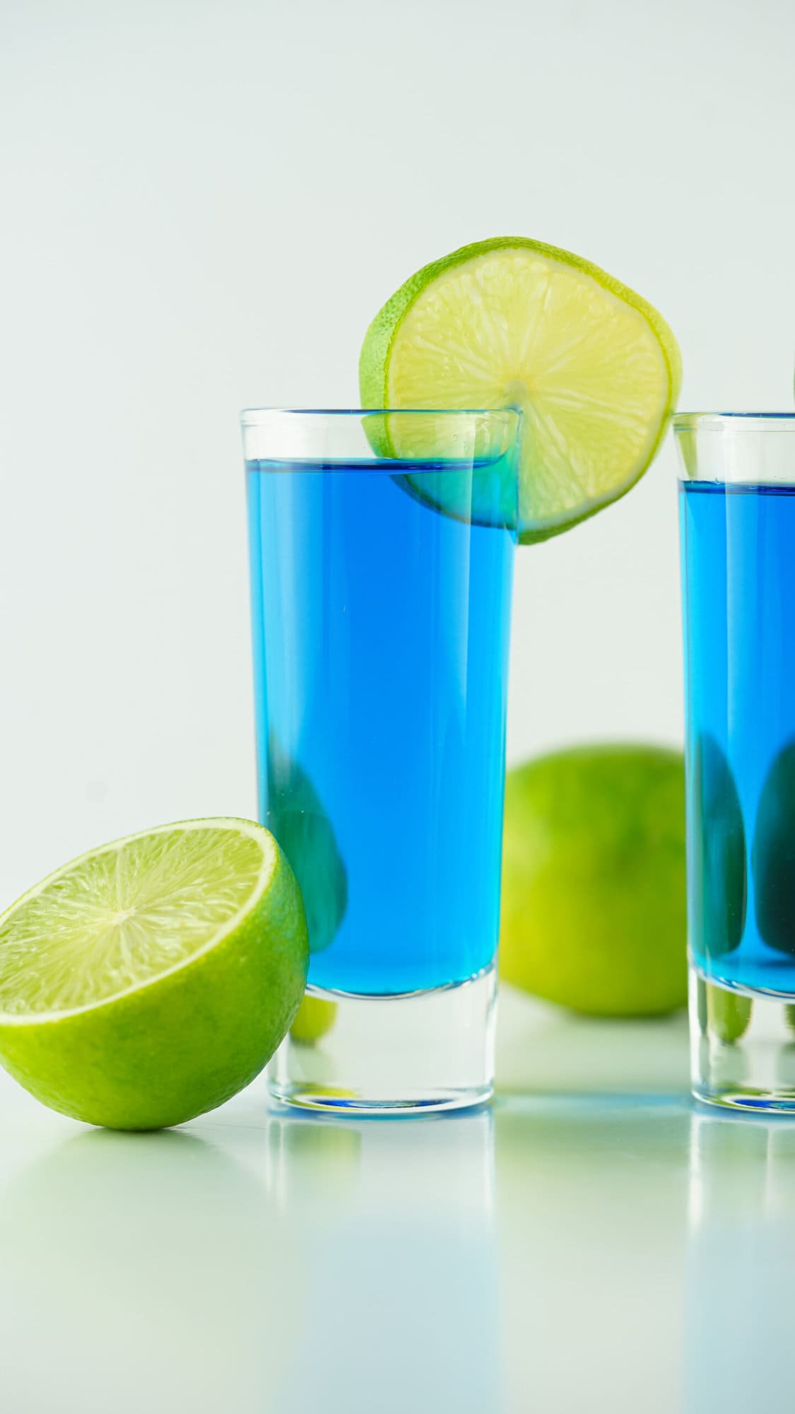 close up of blue kamikaze shot with a slice of lime