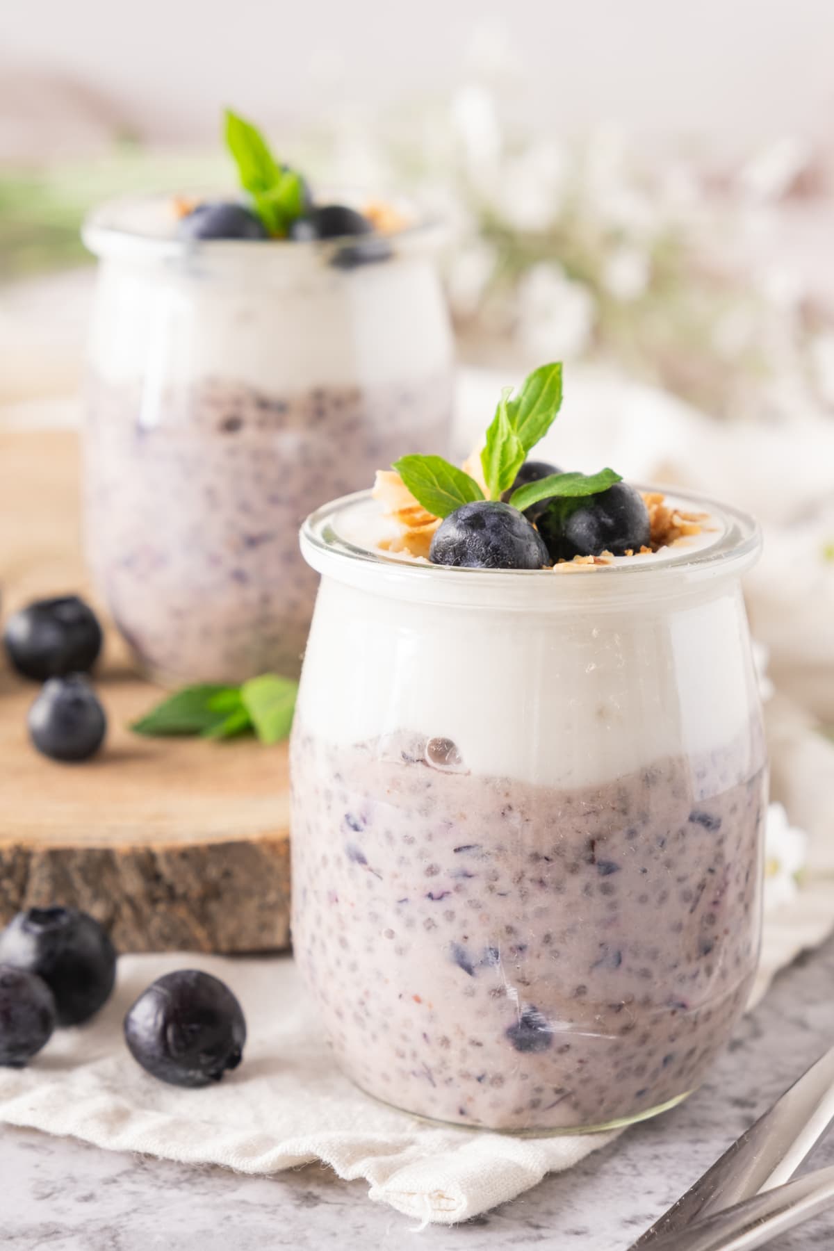 2 jars of chia pudding on a wooden table