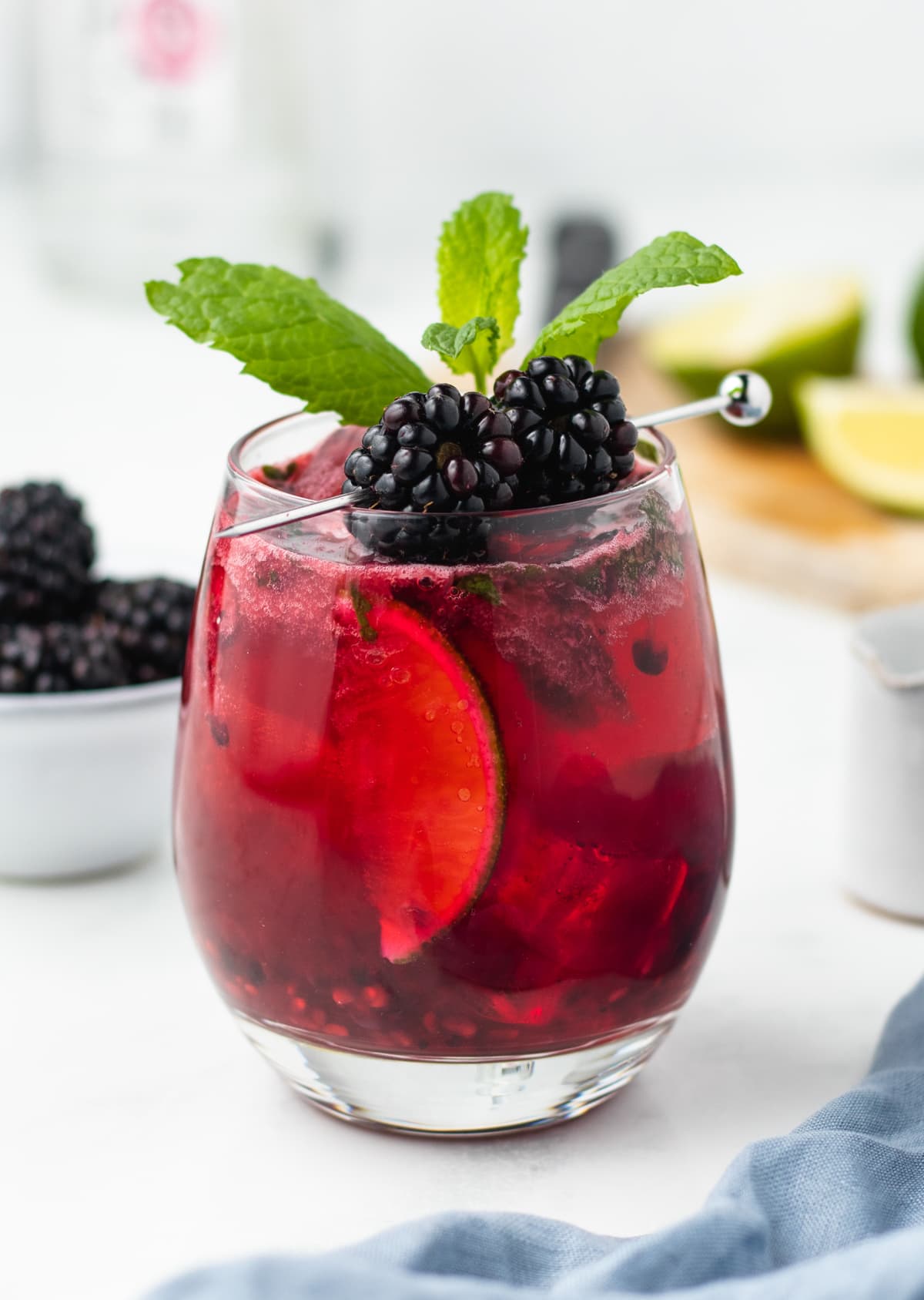 a single blackberry mojito garnished with blackberries and mint