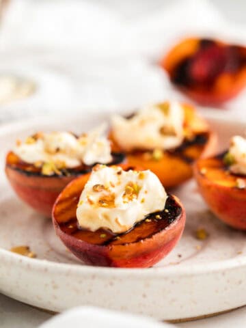 a plate of grilled peaches with vegan mascarpone